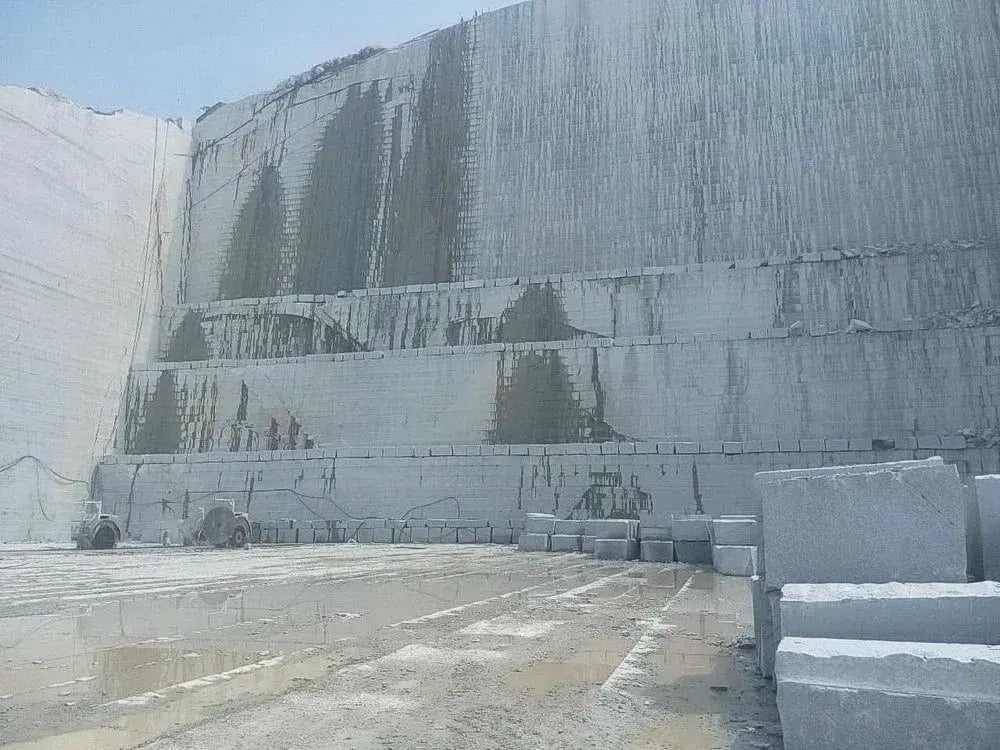 Chelmsford Gray granite quarry in Massachusetts showing massive quarry wall with diamond wire saw cut marks and extracted blocks - the stone that lines Boston's streets