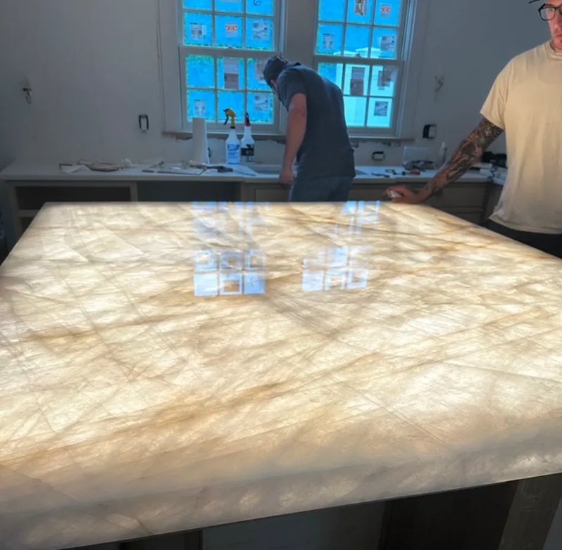  Granite Guy Inc crew installing backlit Cristallo Quartzite island showing gold veining and translucency