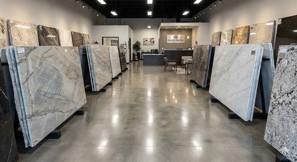 The interior of the Granite Guy Inc. stone showroom in Southborough, MA, featuring various quartzite, granite, and marble slabs on display.