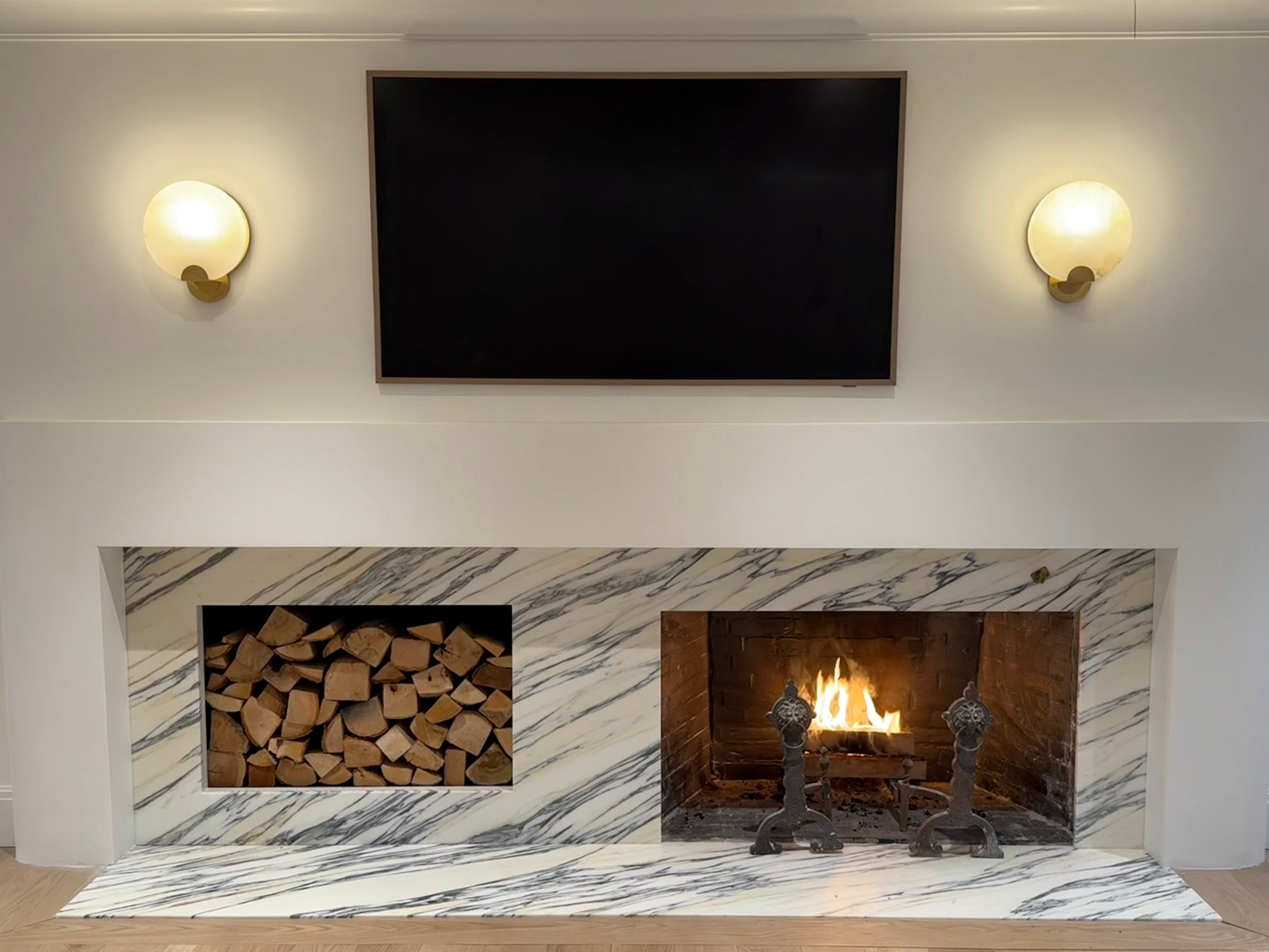 Arabescato Corchia marble fireplace surround with a built-in firewood niche in Wellesley, Massachusetts