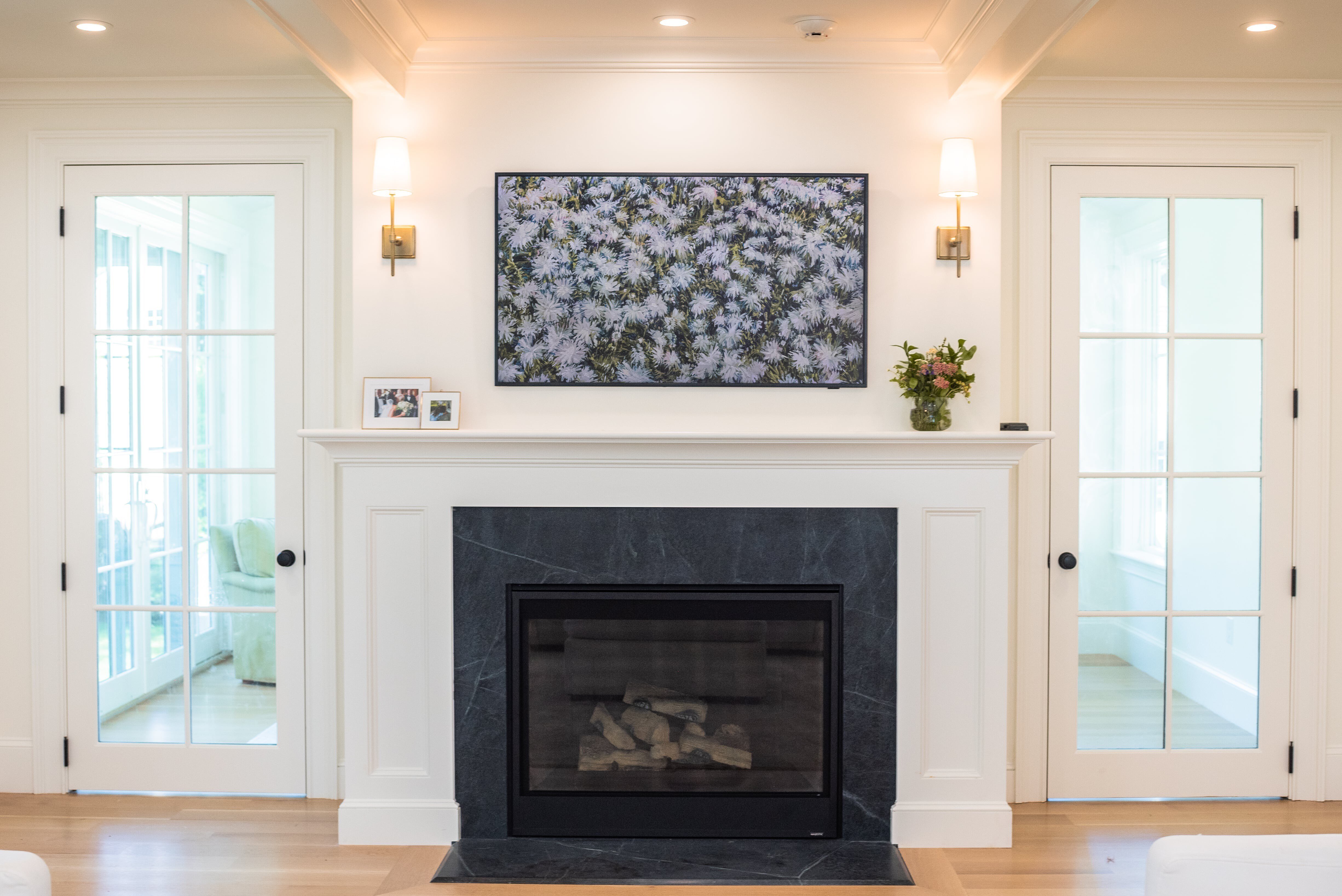 Black soapstone fireplace surround with a white wood mantel in a Wellesley, Massachusetts home