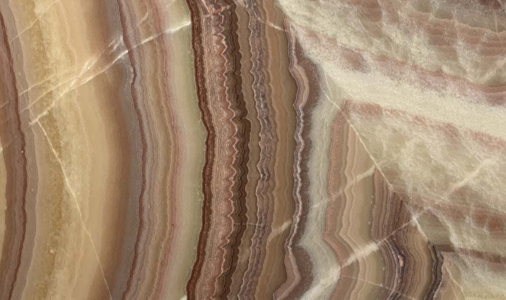 Onyx Arco Iris countertops with soft pink, brown, and cream waves for kitchen countertops. Onyx by Granite Guy Inc.