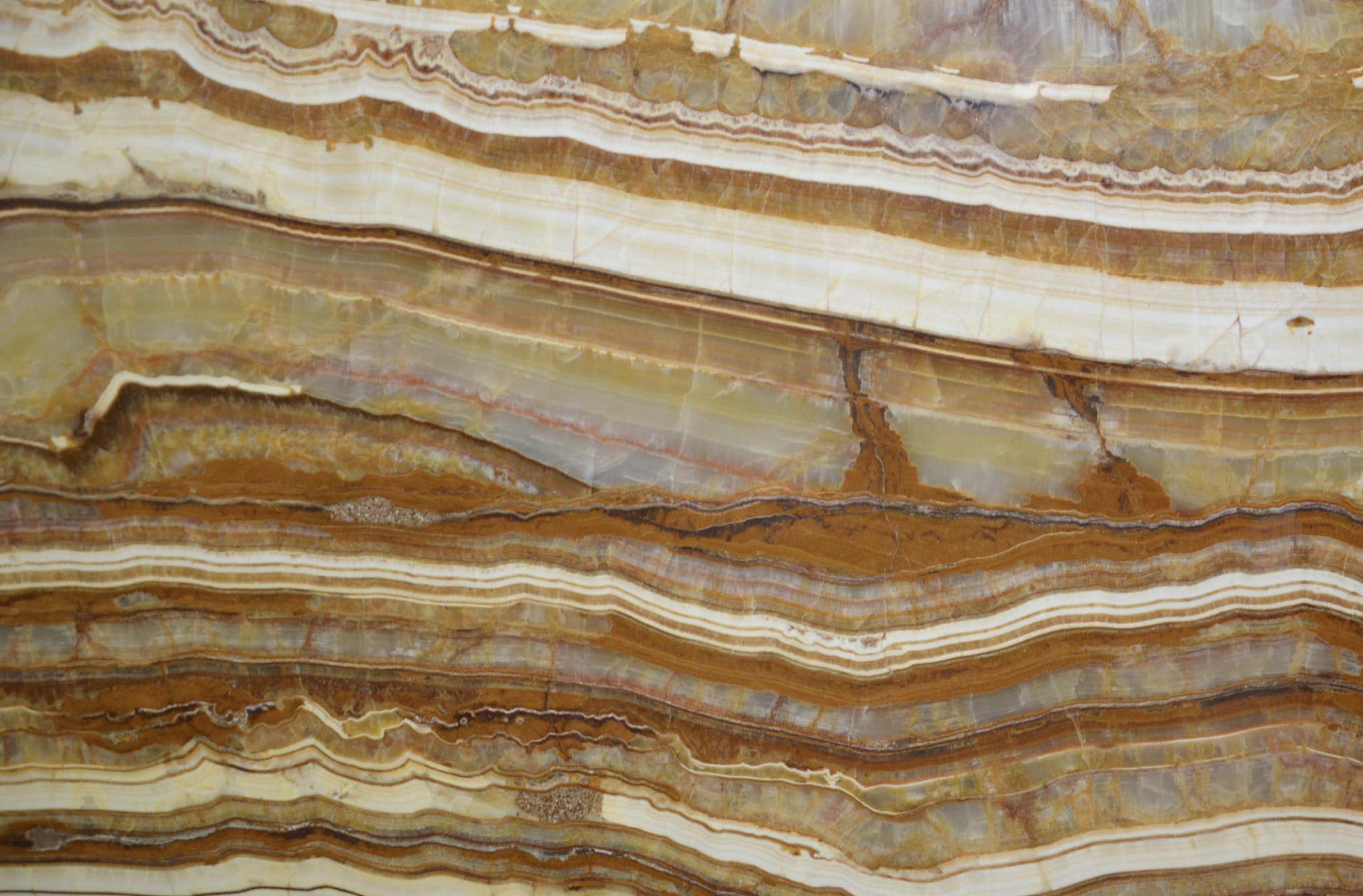 Onyx Brown Fantasy countertops with layered gold and beige tones, striking for kitchen countertops. Onyx by Granite Guy Inc.