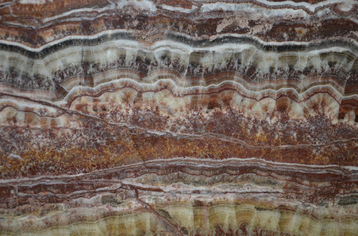 Onyx Fantastico countertops with bold red, gold, and cream layers for kitchen countertops. Onyx by Granite Guy Inc.