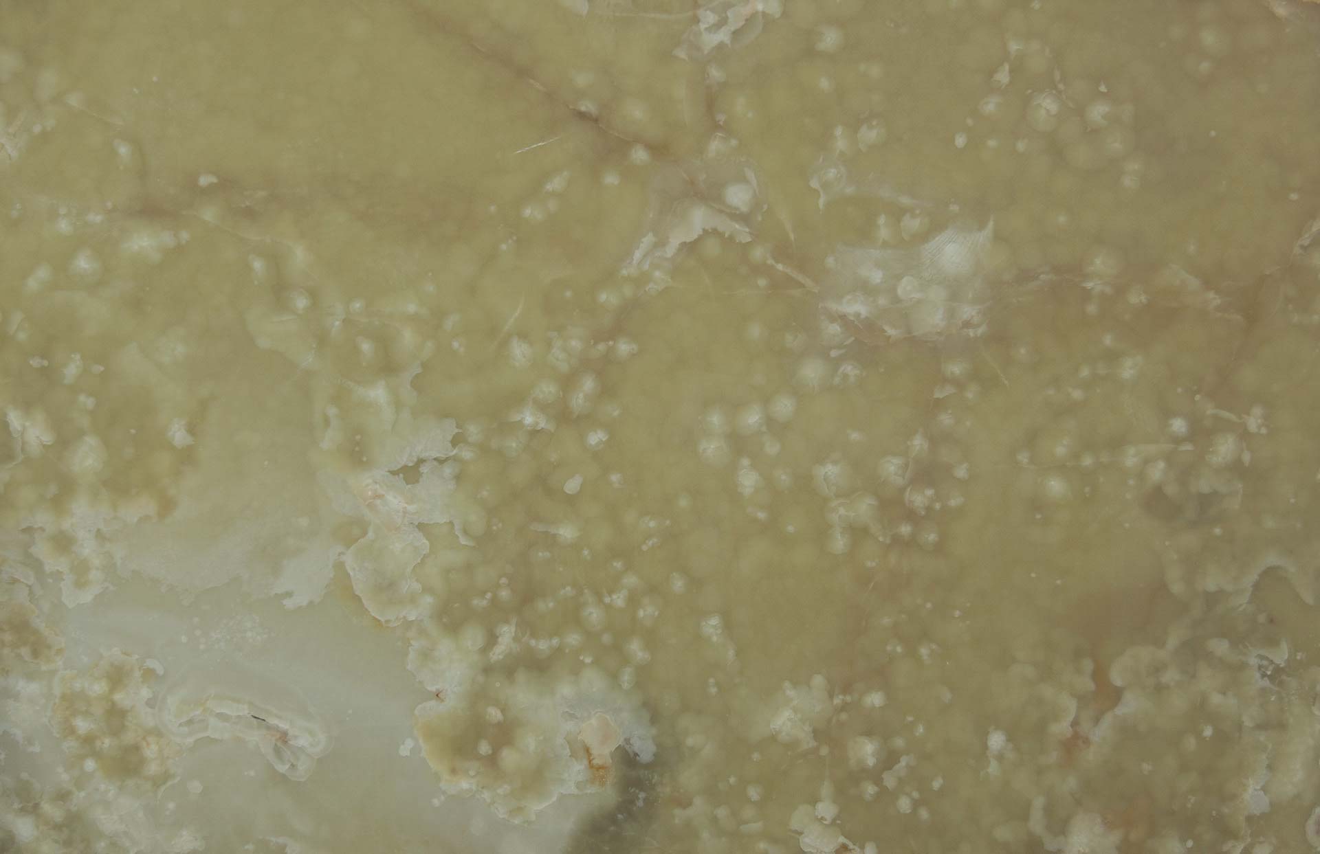 Onyx Green Cream countertops with translucent olive tones and cloudy white textures for kitchen countertops. Onyx by Granite Guy Inc.