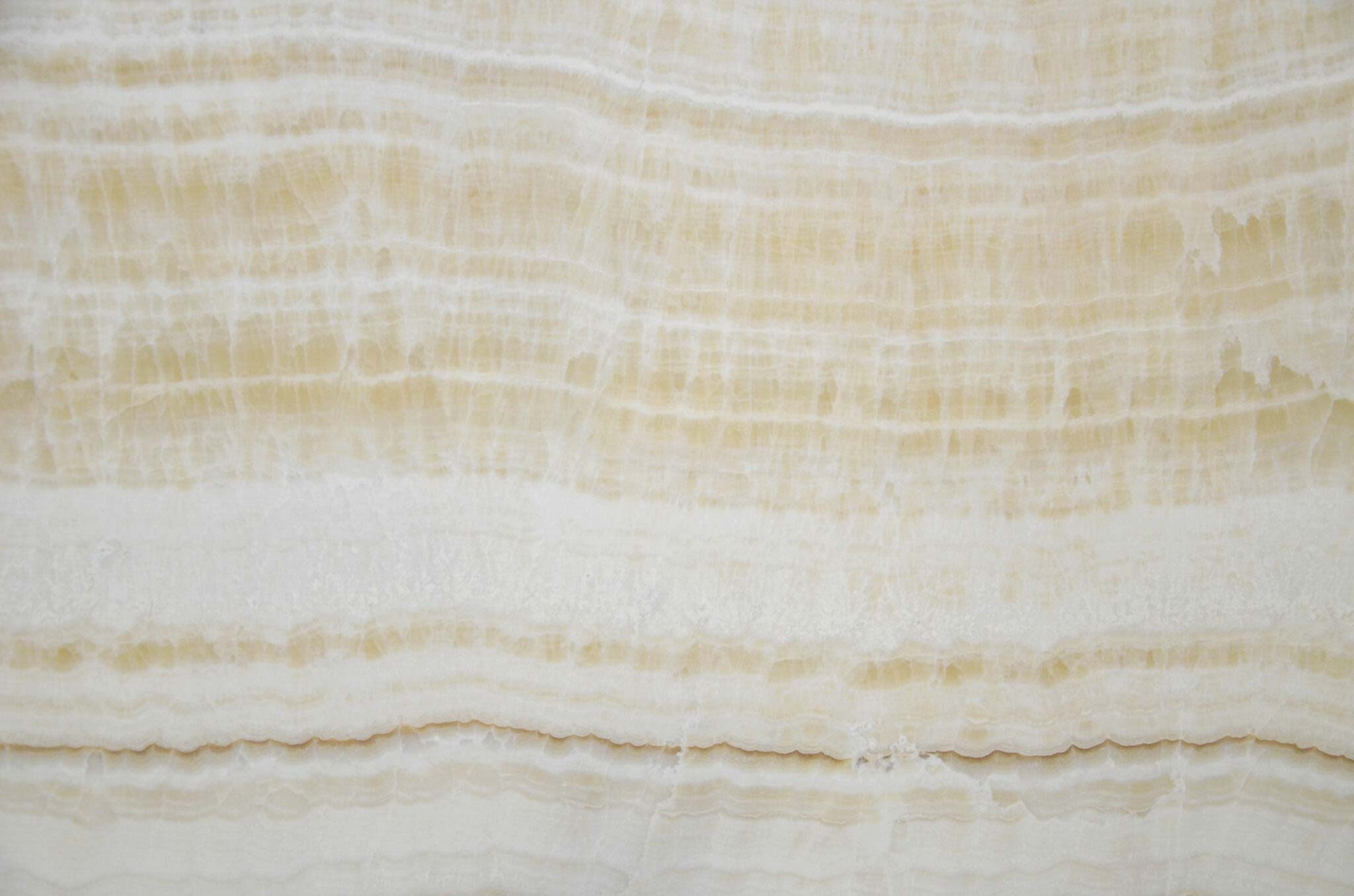Onyx Ivory Polished countertops with warm yellow tones and soft creamy layers for kitchen countertops. Onyx by Granite Guy Inc.