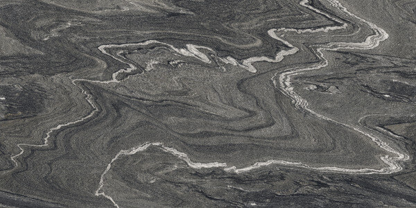 SapienStone Silver Wave porcelain kitchen countertops with bold charcoal, gray, and white flowing pattern by Granite Guy Inc.