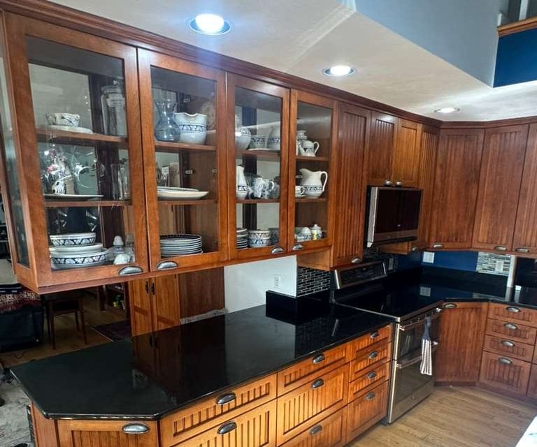 Black Pearl granite countertops on a kitchen peninsula with cherry cabinets in a Massachusetts home