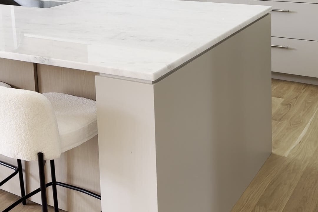 Eased edge countertop on a Pegasus White marble kitchen island in Lexington, MA