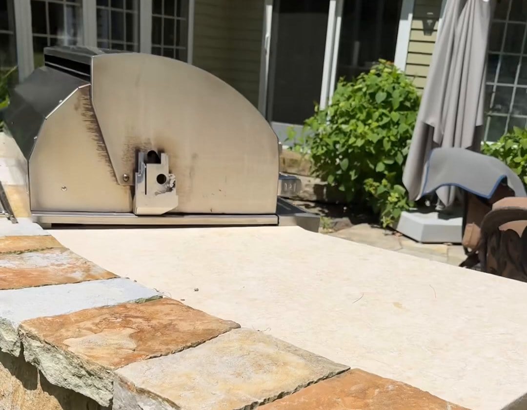 Jerusalem Gold limestone outdoor countertop beside a built-in grill in Weston, Massachusetts