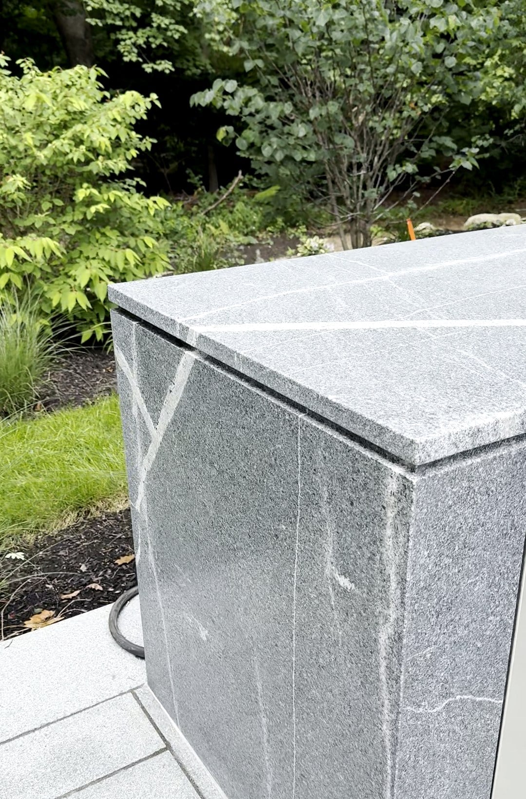 Honed Silver Waves granite outdoor kitchen island with granite-clad sides in Lexington, Massachusetts
