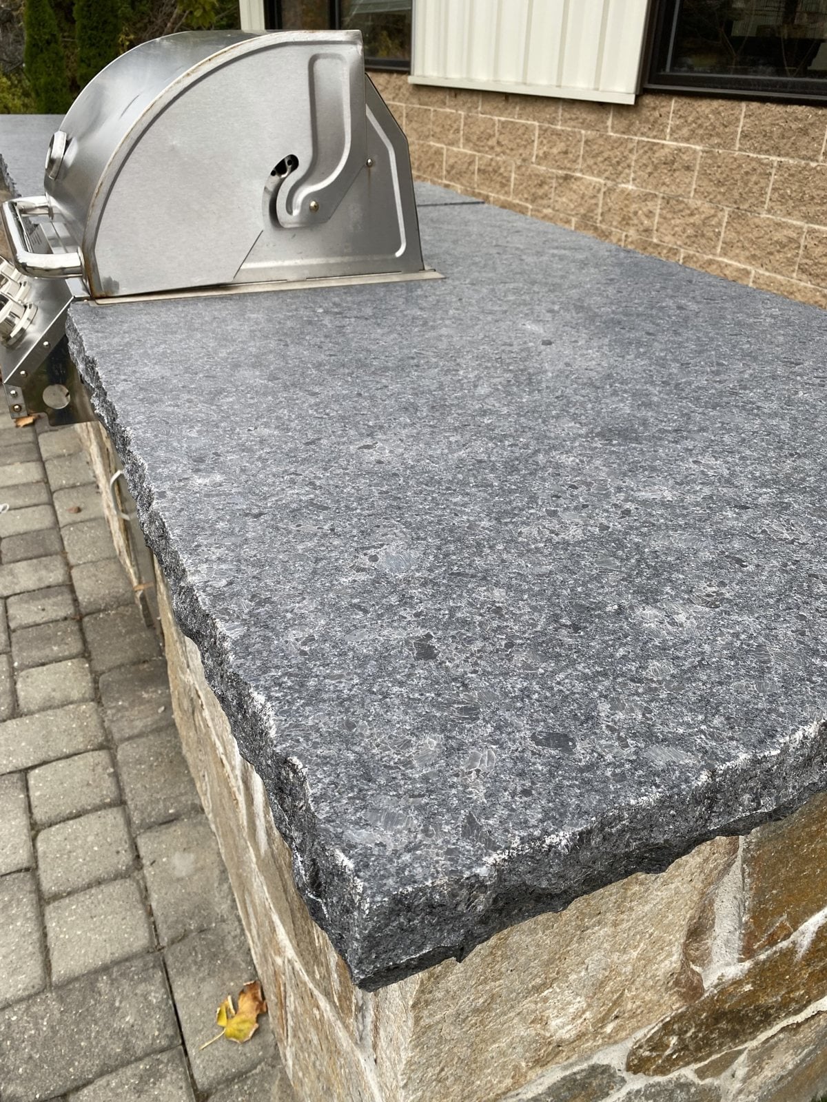 Steel Gray leathered granite outdoor countertop with a chiseled edge, outside for over 10 years at the Granite Guy shop in Southborough, Massachusetts