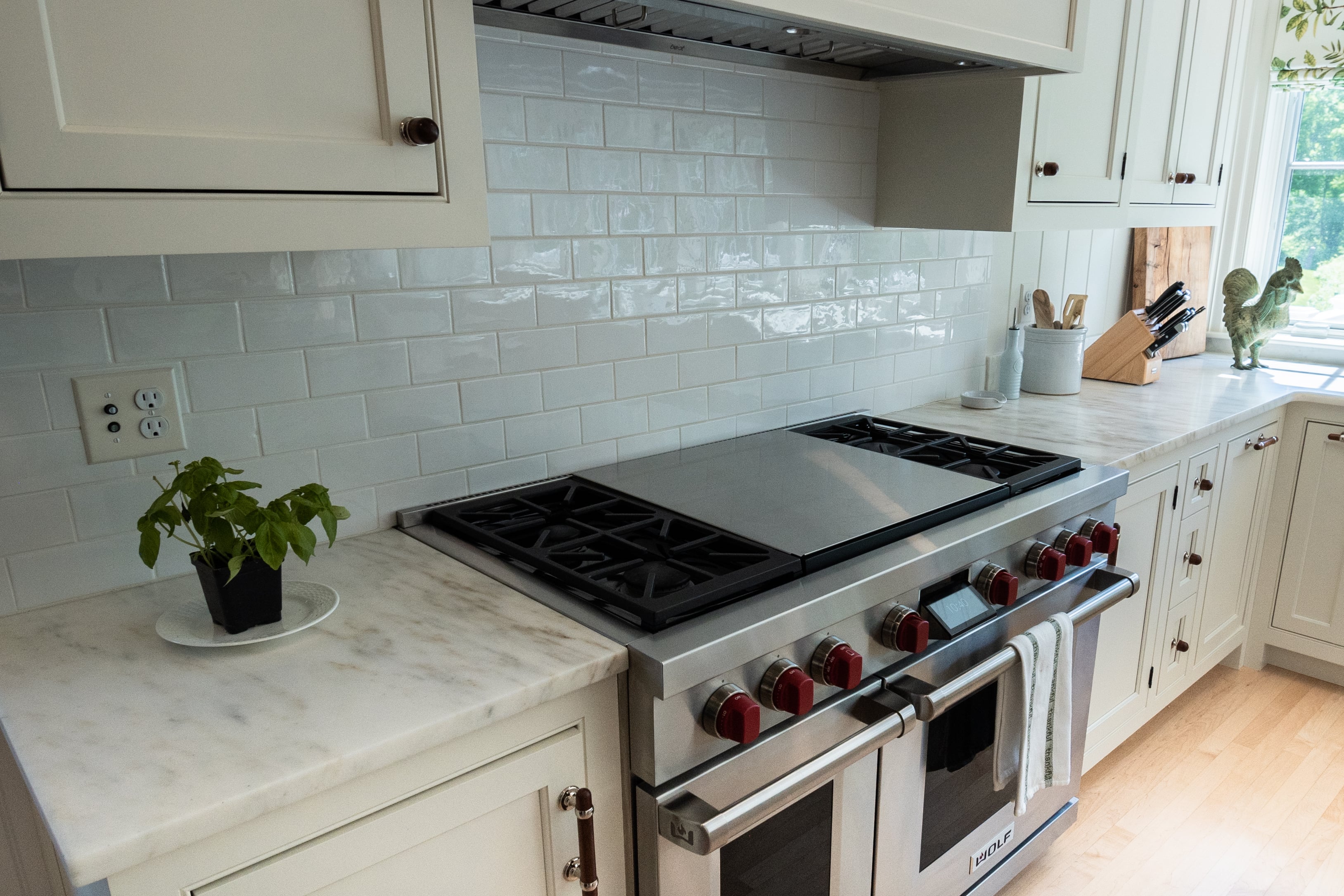 Suede-finish Imperial Danby marble countertops beside a gas range in a Southborough, Massachusetts kitchen