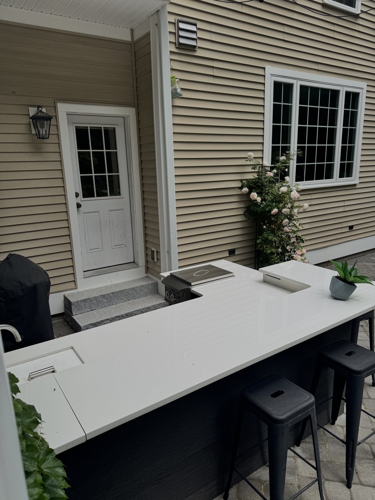White polished porcelain outdoor bar countertop with stools at a Massachusetts home